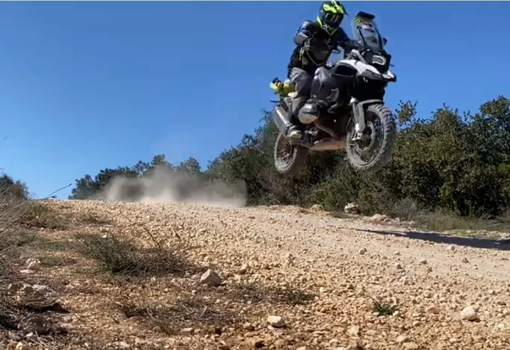 Sprung mit einer großen Reiseenduro auf einer Schotterpiste